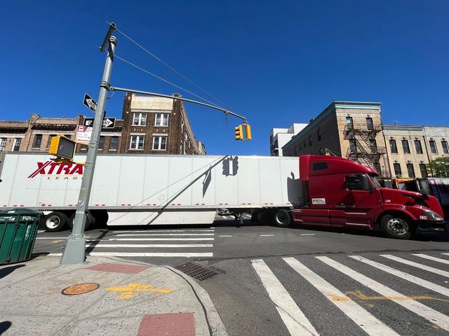 A truck drives through a busy intersection in Manhattan.